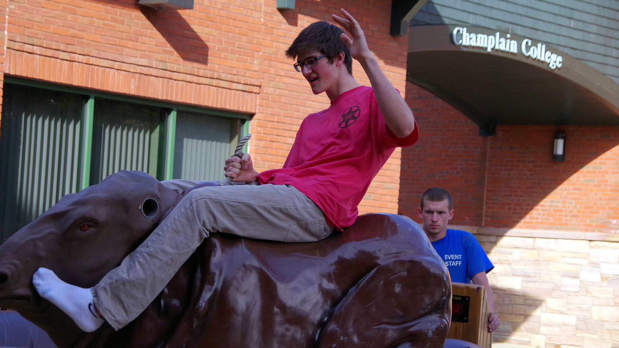 a student riding a mechanical bull in the courtyard