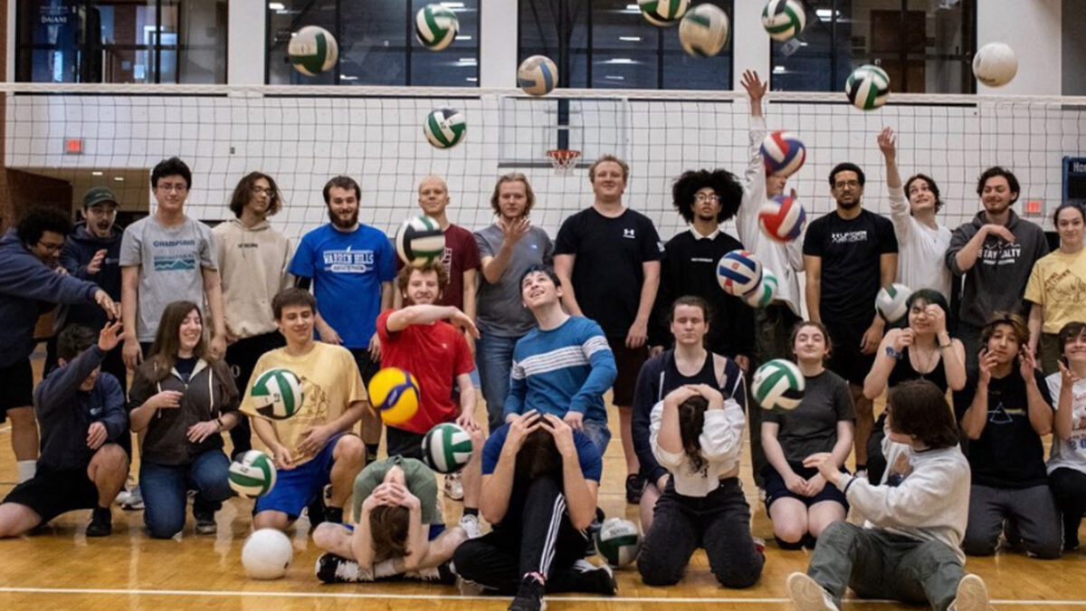 champlain's volleyball club posing for a group photo and throwing volleyballs in the air