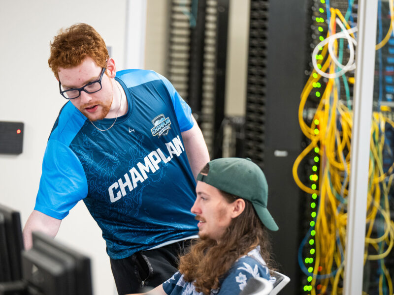 Two students work alongside each other at the Cyber Range at Champlain College.