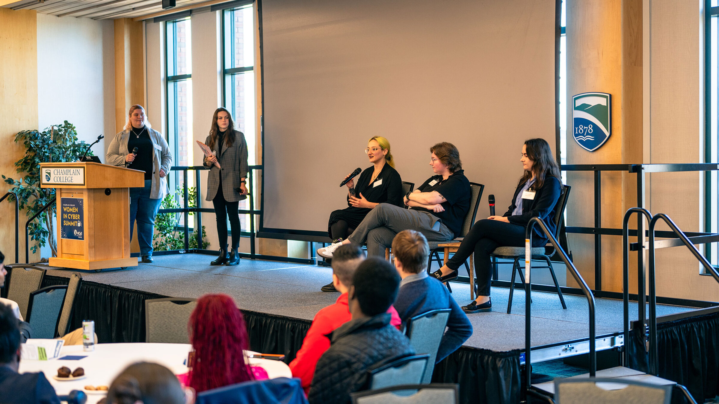 Mackenzie Marsocci ’20, Emily Platz ’20, and Samantha Moench ’17 on stage at the Women in Cyber Summit