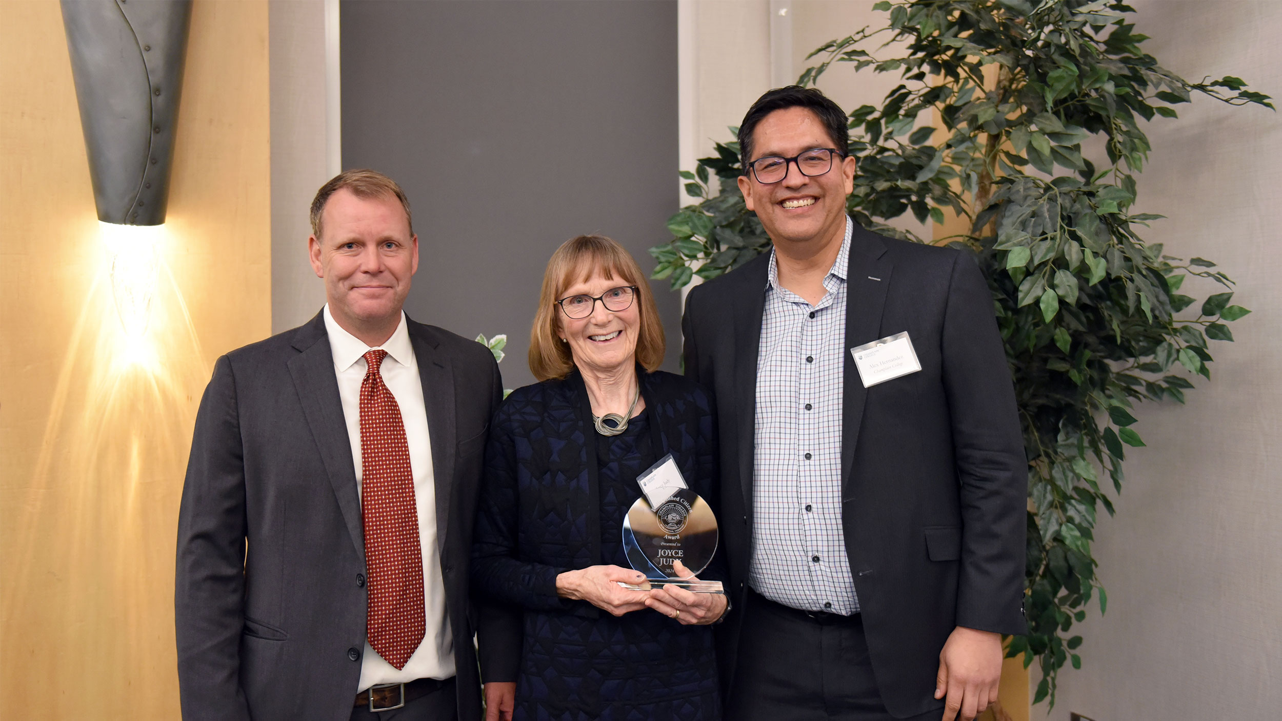 david smith, joyce judy, and alex hernandez pose for a photo while joyce holds her award