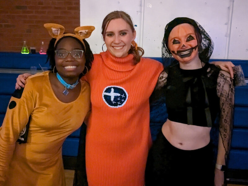 three students in halloween costumes