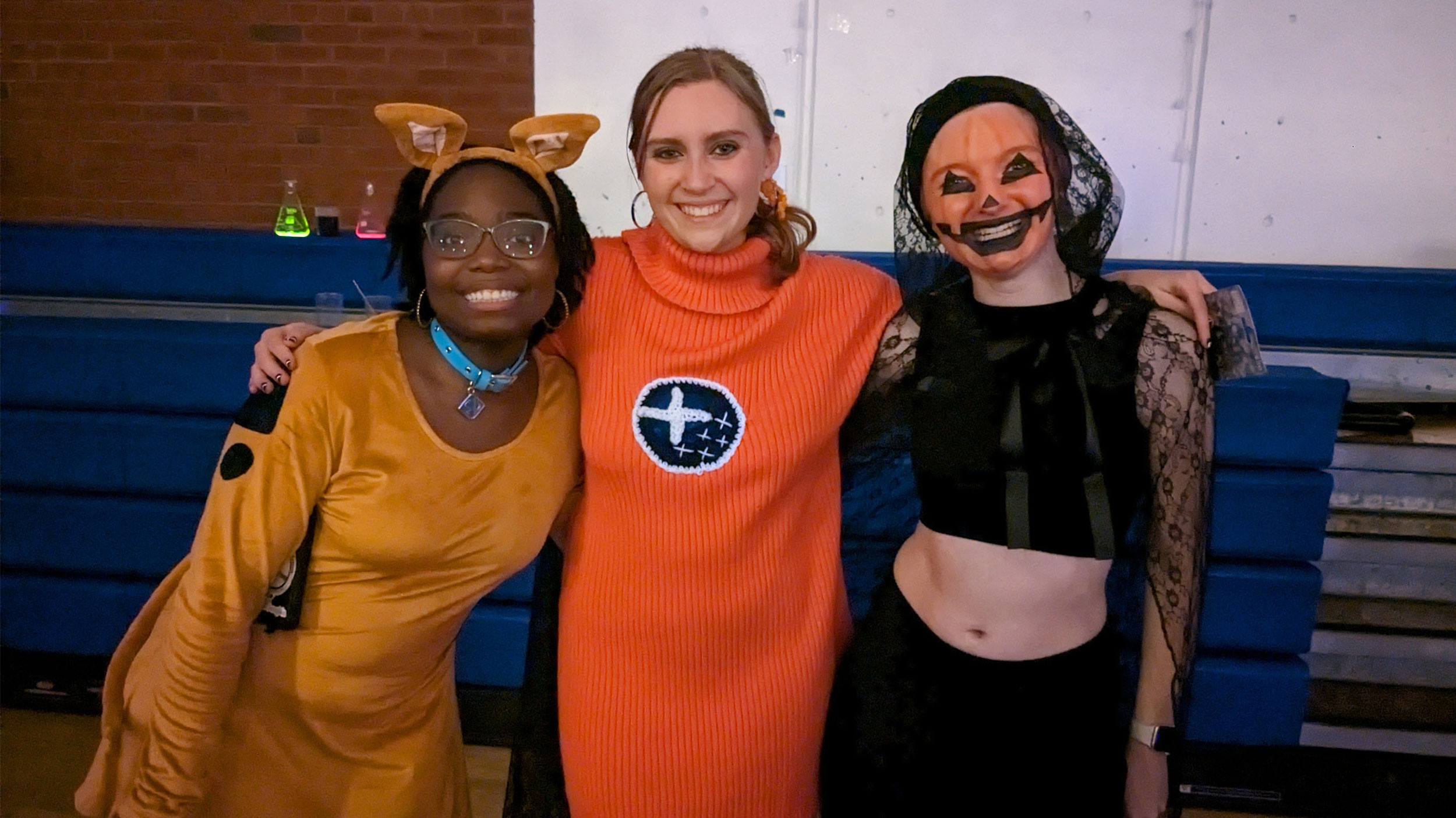 three students in halloween costumes