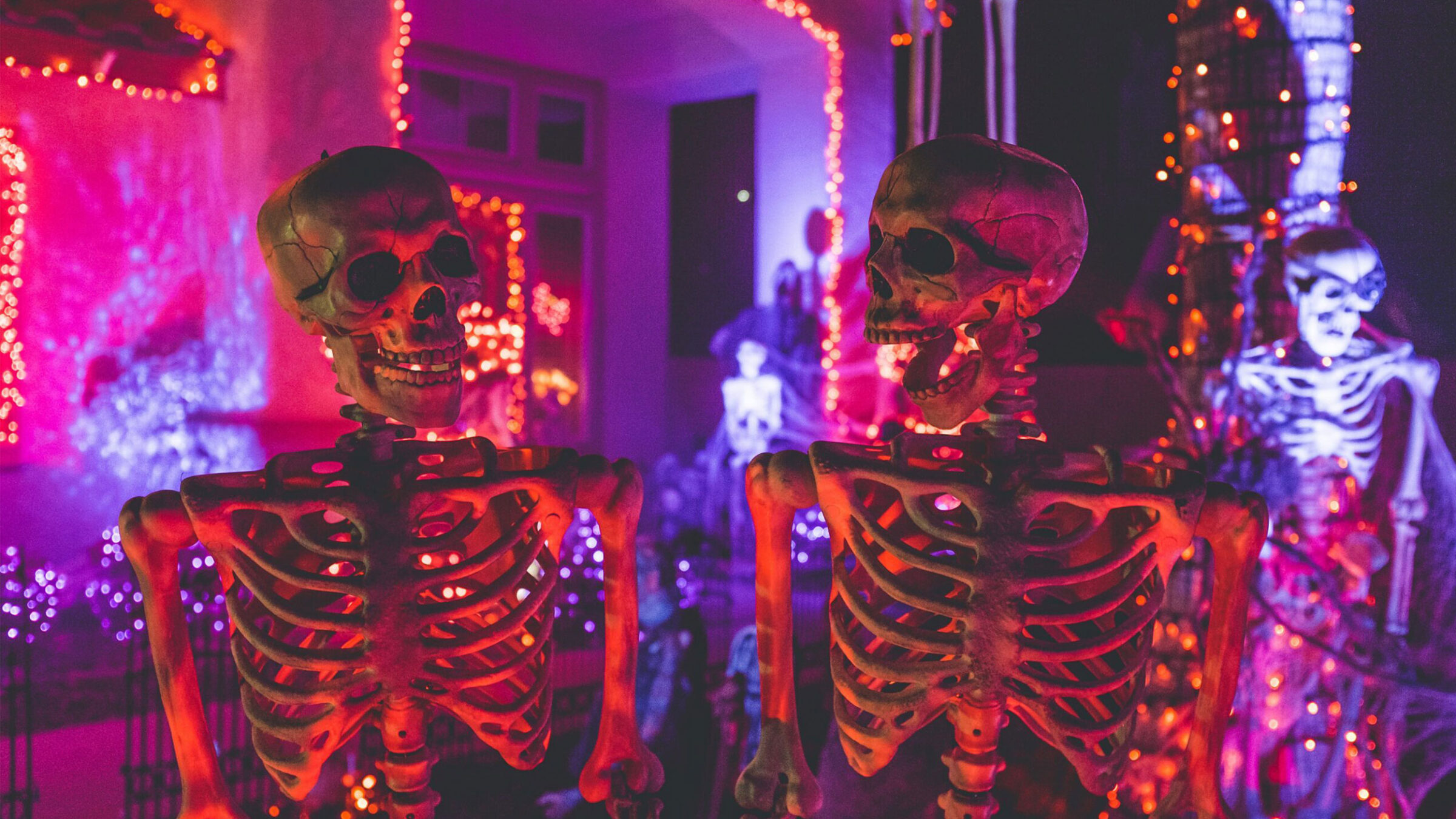 halloween decorations and skeletons surrounded by purple and red lights