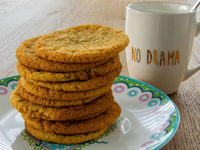 10 cookies piled on top of each other next to a mug that reads "no drama"