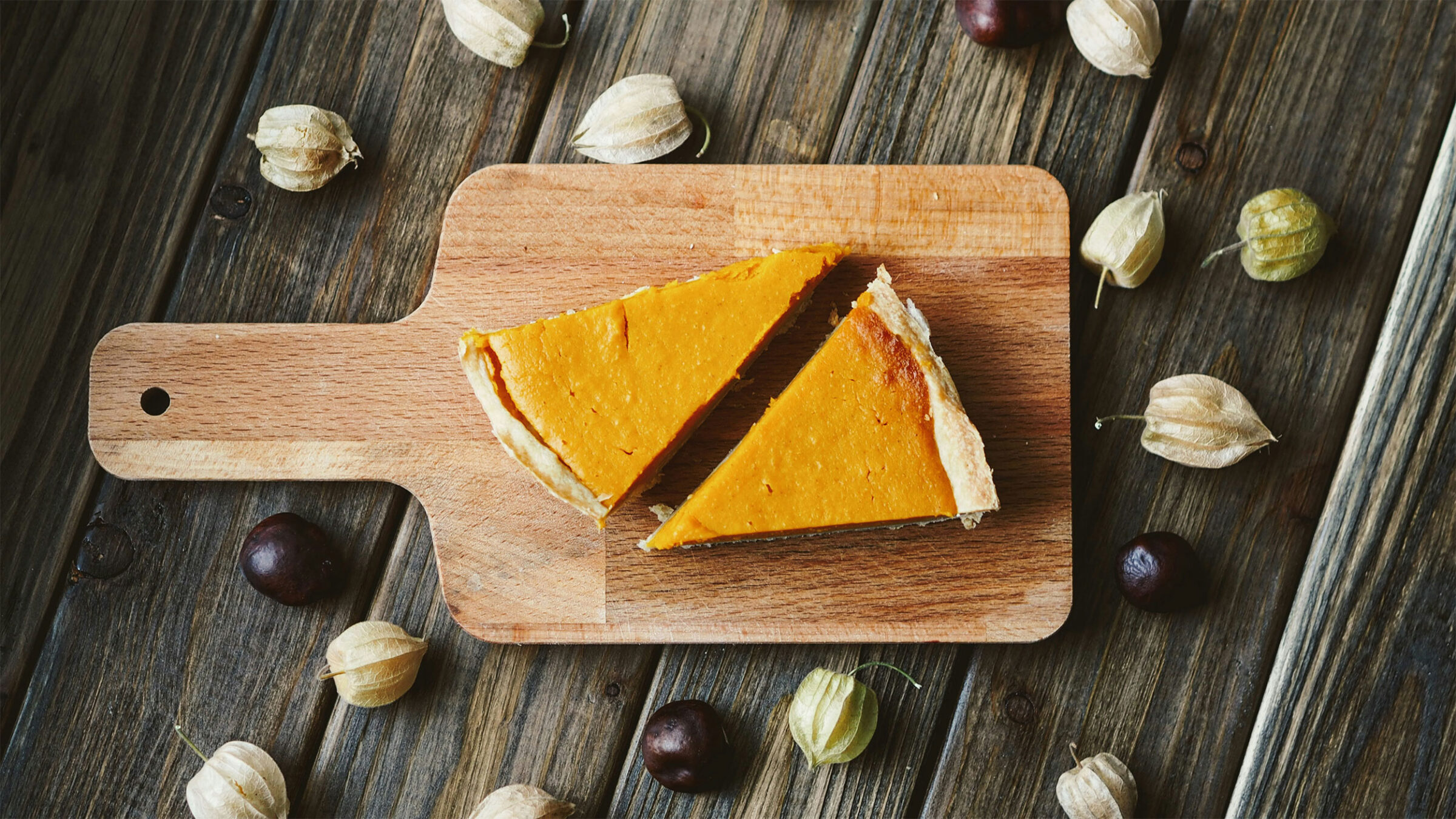 two slices of pumpkin pie on a cutting board