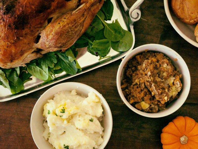 thanksgiving meal on the table with turkey, mashed potatoes, and stuffing