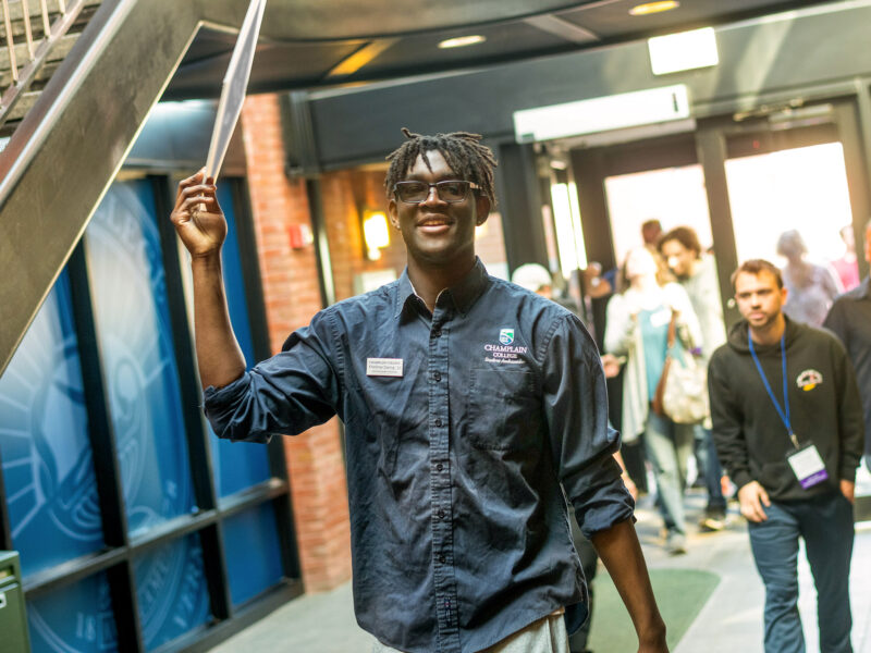 student ambassador holds up a sign during a campus tour