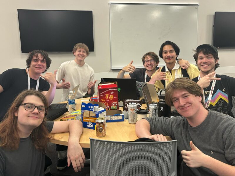 A group of game design students pose for the camera in the midst of a game-making contest.