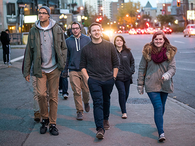 A group of students confidently walk along the street in Montreal, Canada